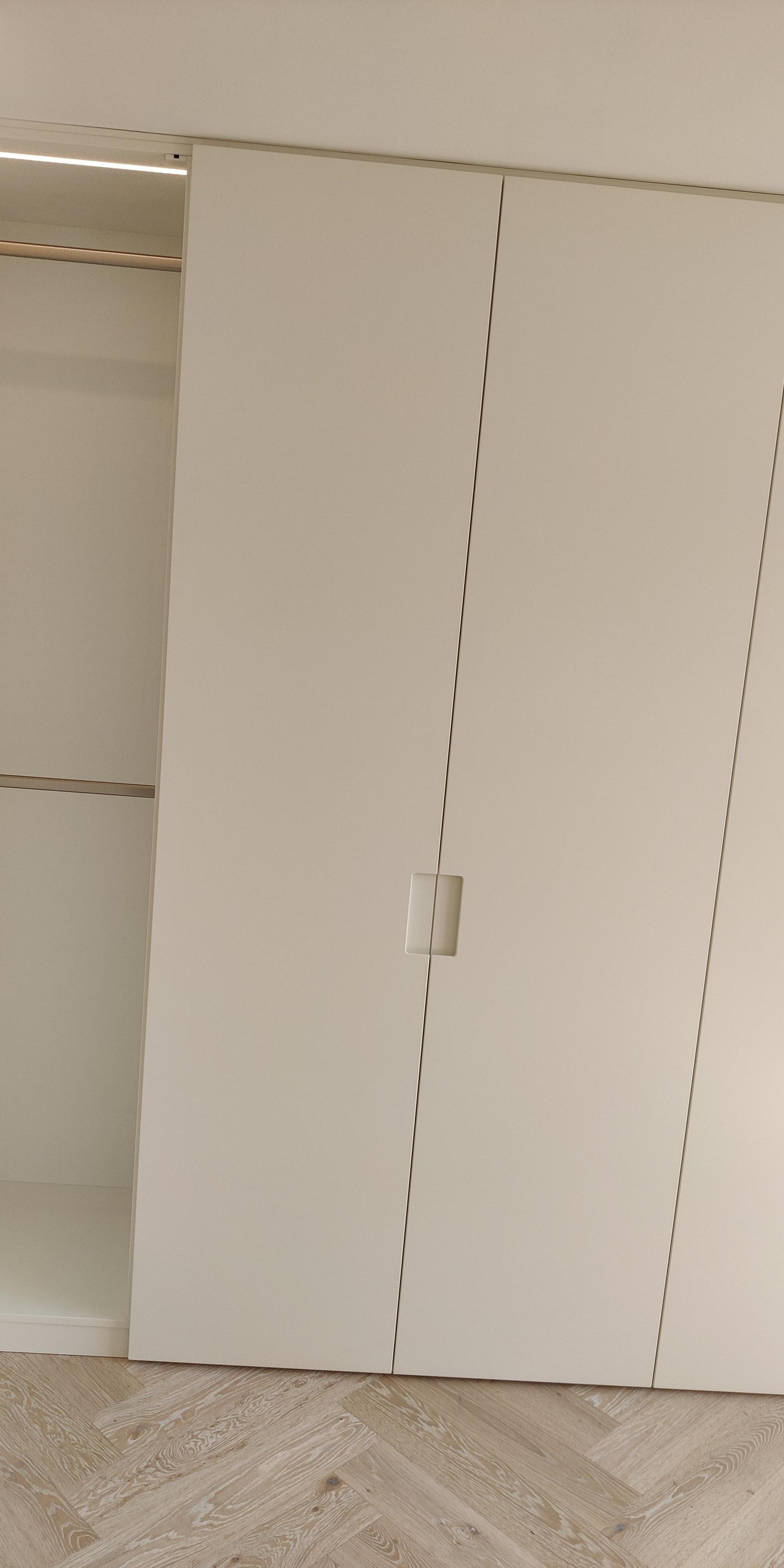 Weißer Einbauschrank nach Maß mit geöffneter Schranktür und integrierter Innenbeleuchtung