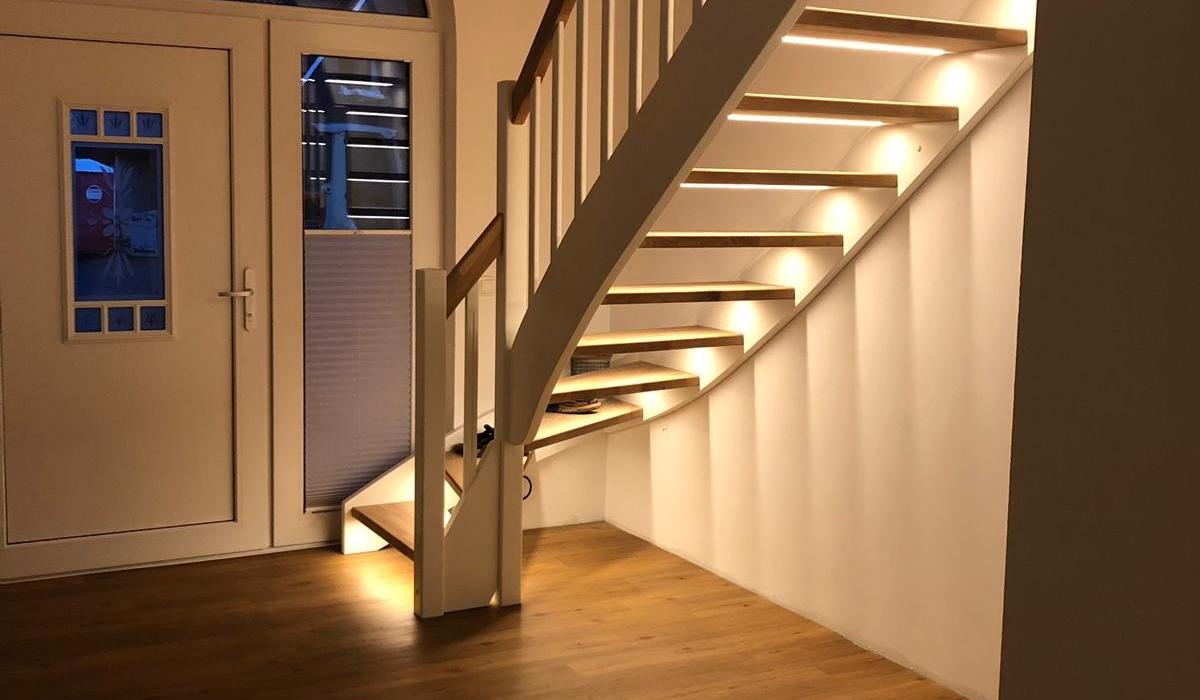 Maßgefertigte Holztreppe mit weißem Geländer und integrierter LED-Beleuchtung