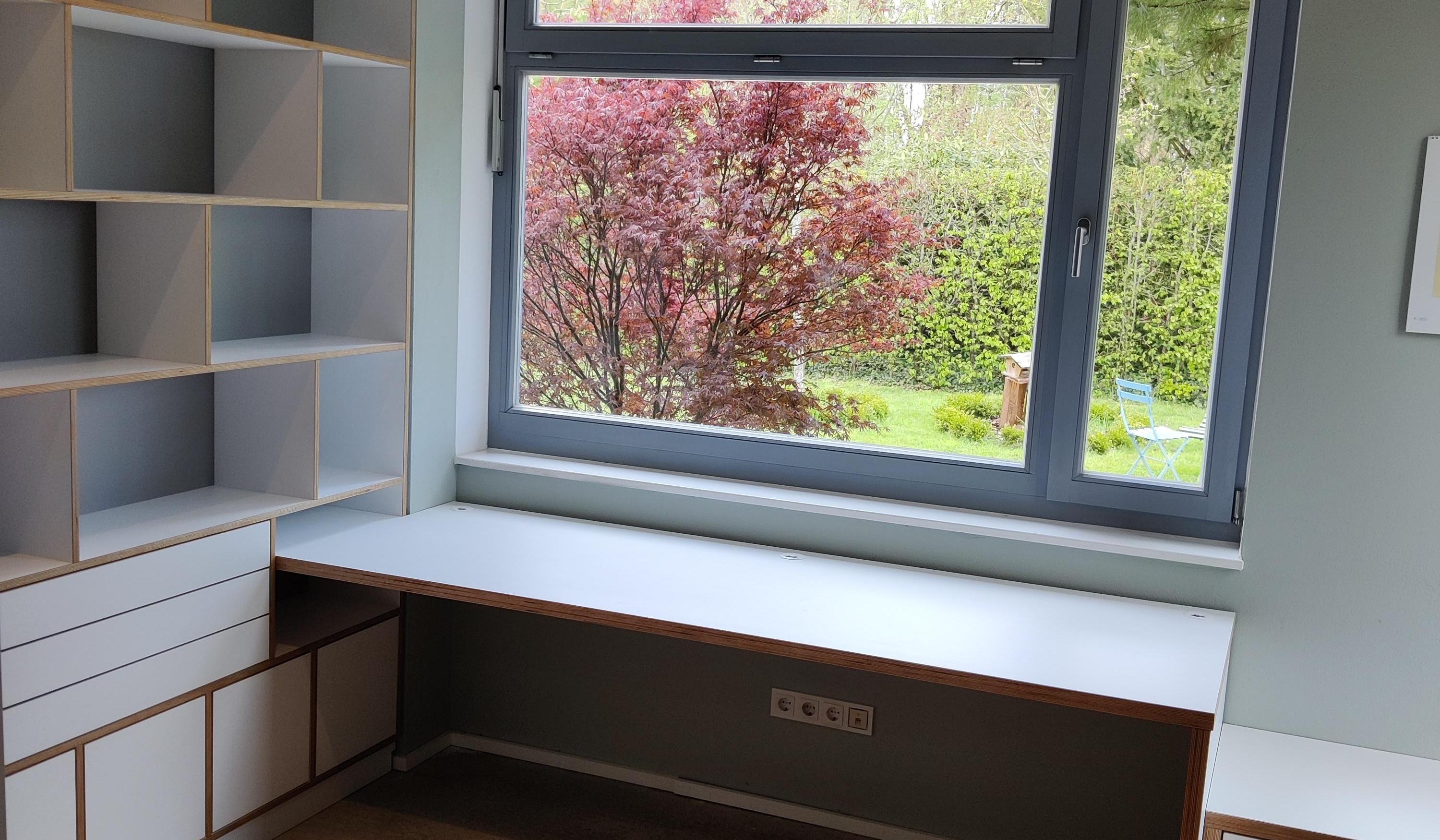Maßgefertigter Schreibtisch am Fenster mit individuellem Regalsystem und Stauraum vom Tischler