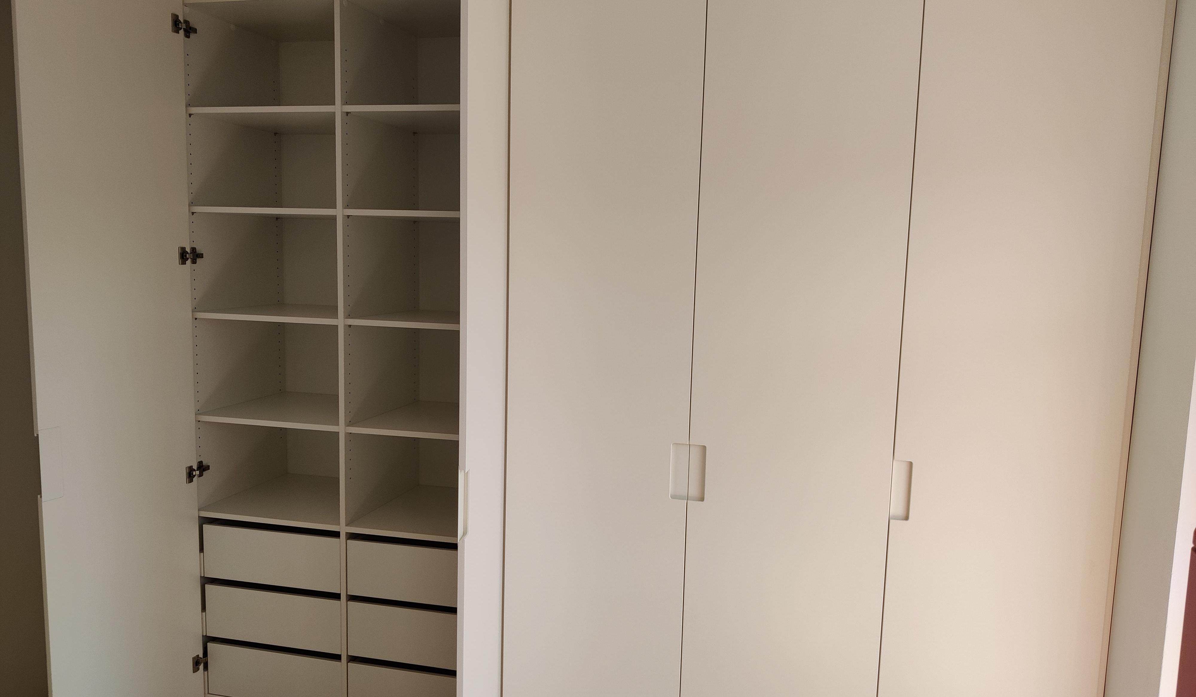 Geöffneter maßgefertigter Einbauschrank in Weiß mit Regalböden und Schubladen