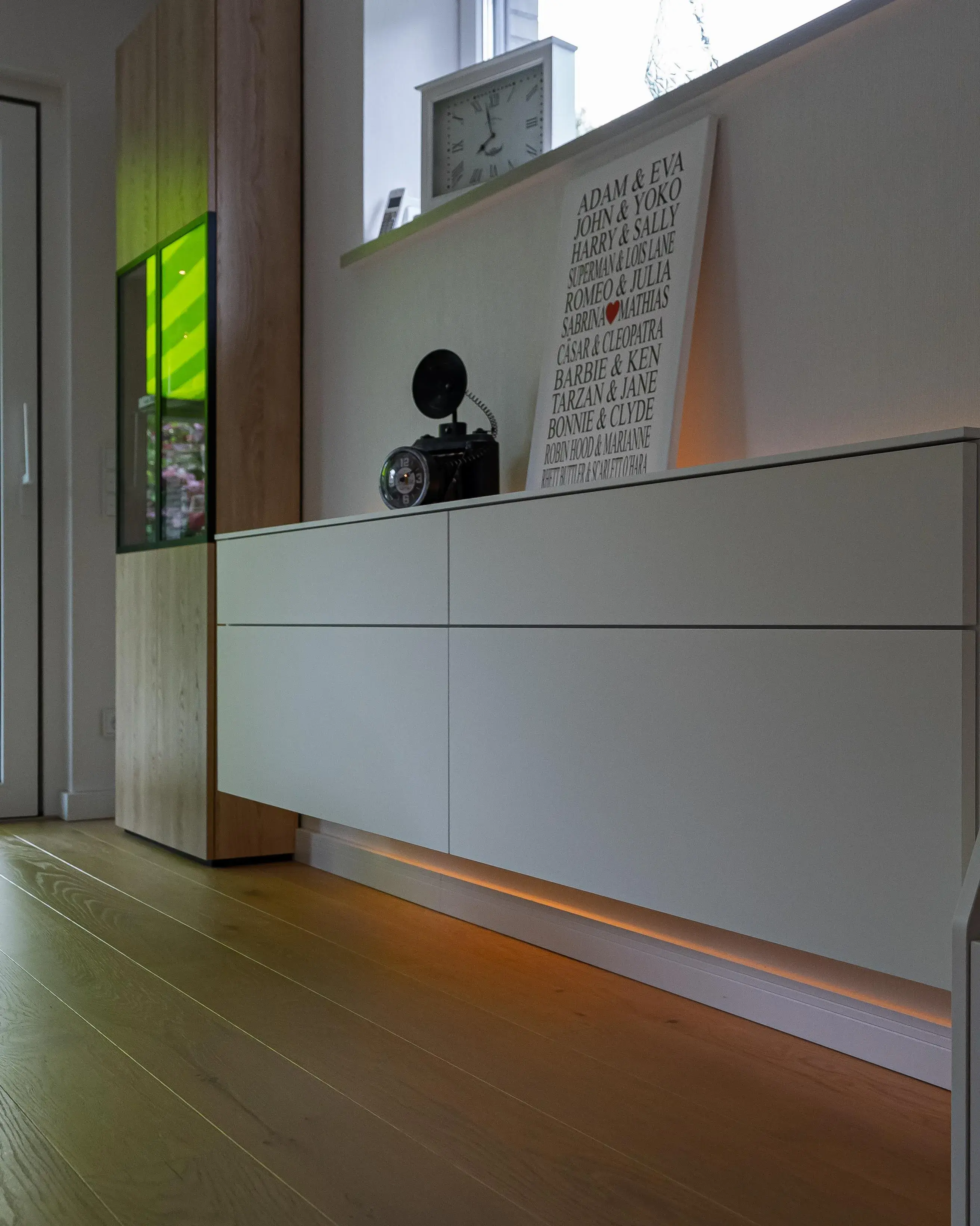 Modernes weißes Sideboard mit grifflosen Fronten und indirekter LED-Beleuchtung am Sockel