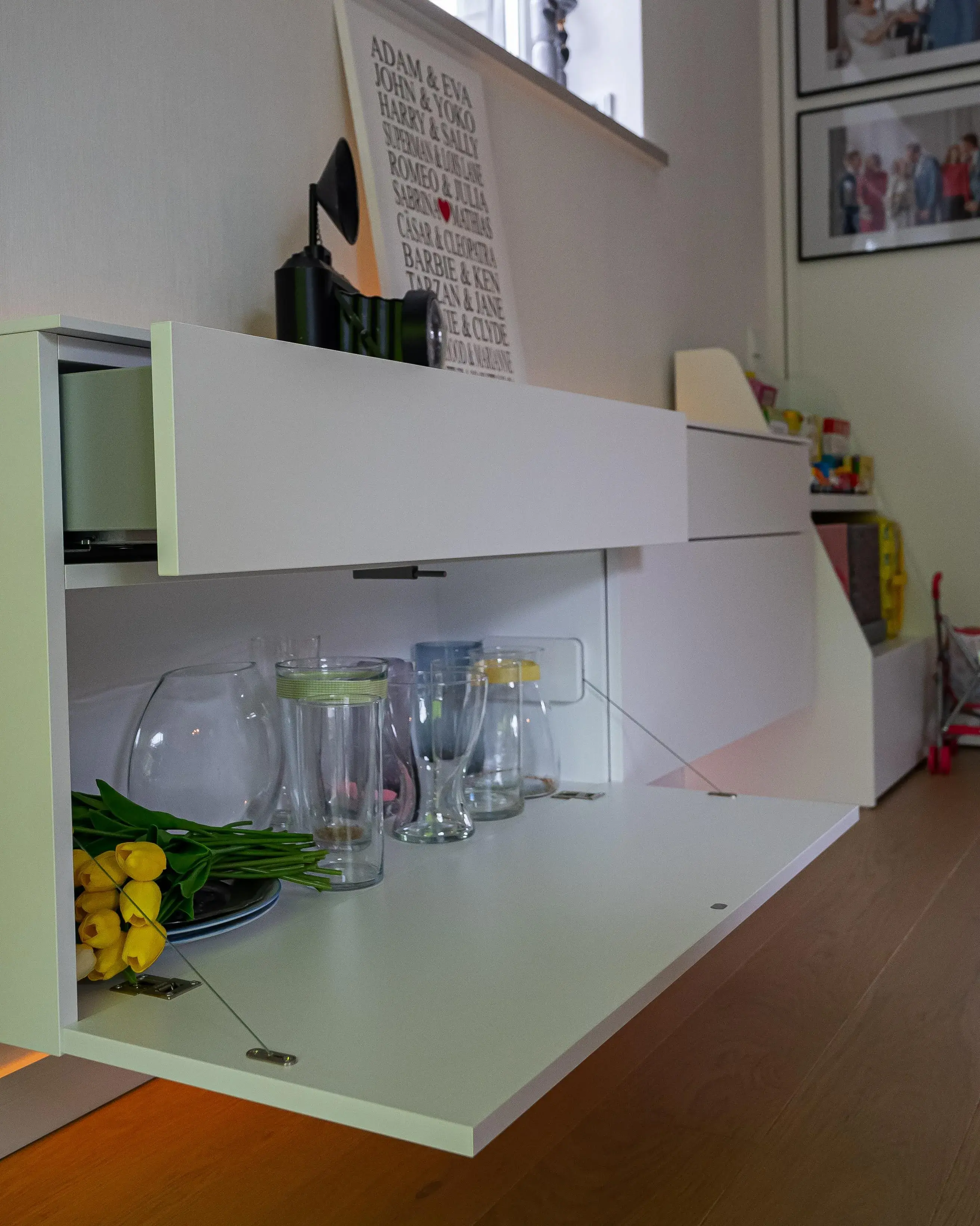 Weißes griffloses Sideboard mit geöffneter Schublade und ausklappbarer Ablagefläche