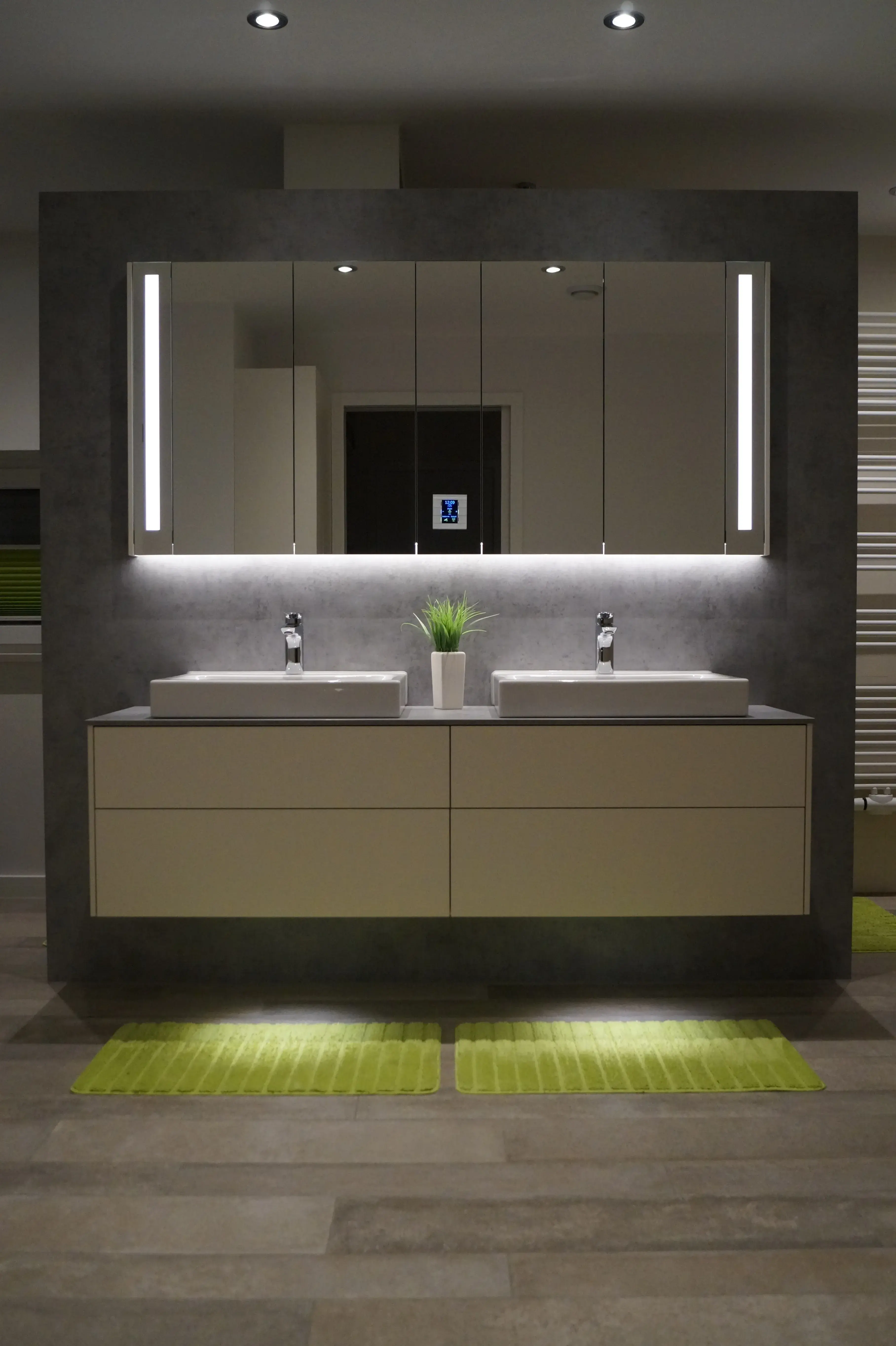 Modernes Badezimmer mit Doppelwaschtisch, grifflosen Badmöbeln und großem Spiegelschrank mit integrierter LED-Beleuchtung