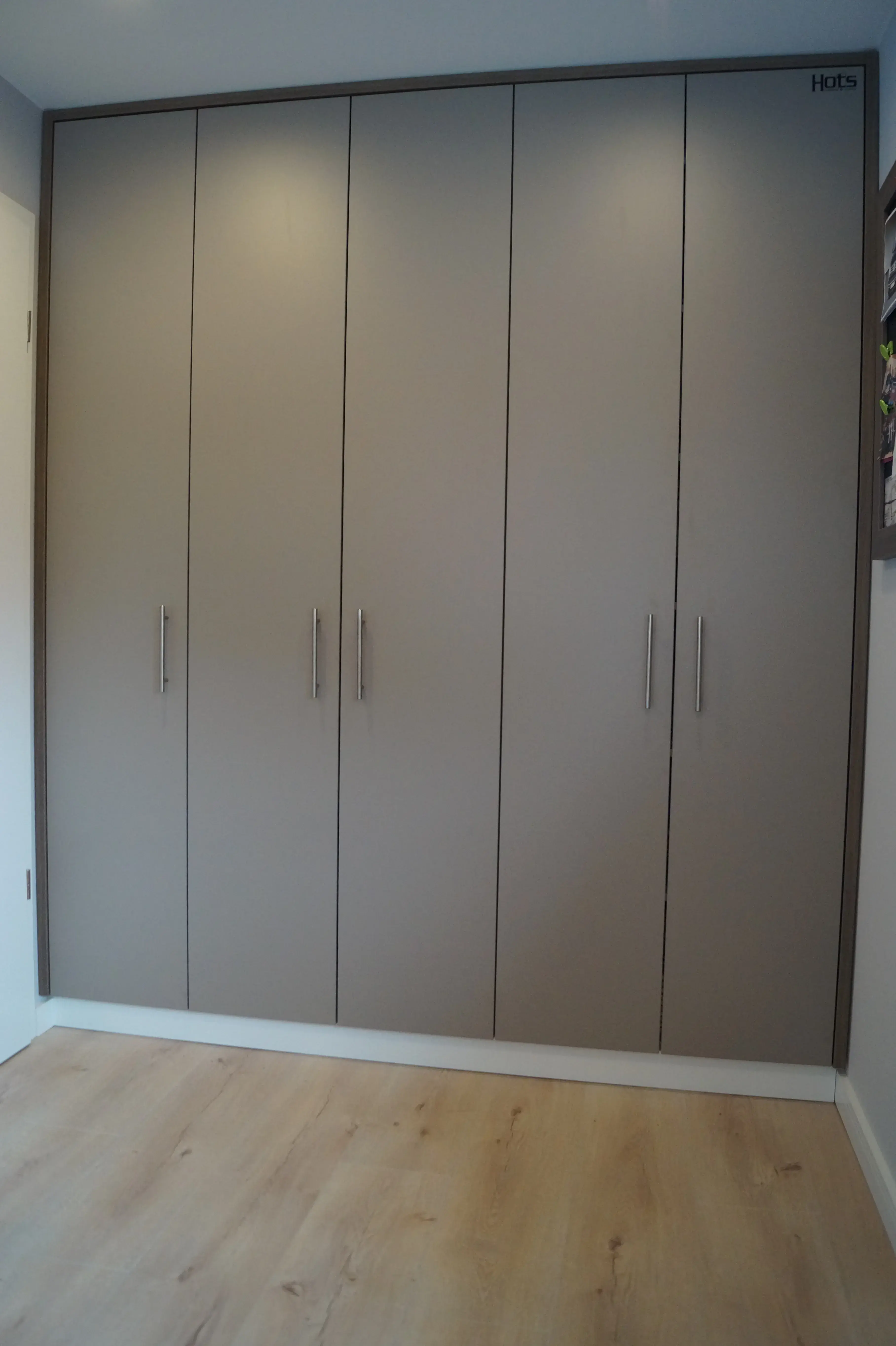 Maßgefertigter deckenhoher Einbauschrank mit grauen Fronten und viel Stauraum vom Tischler