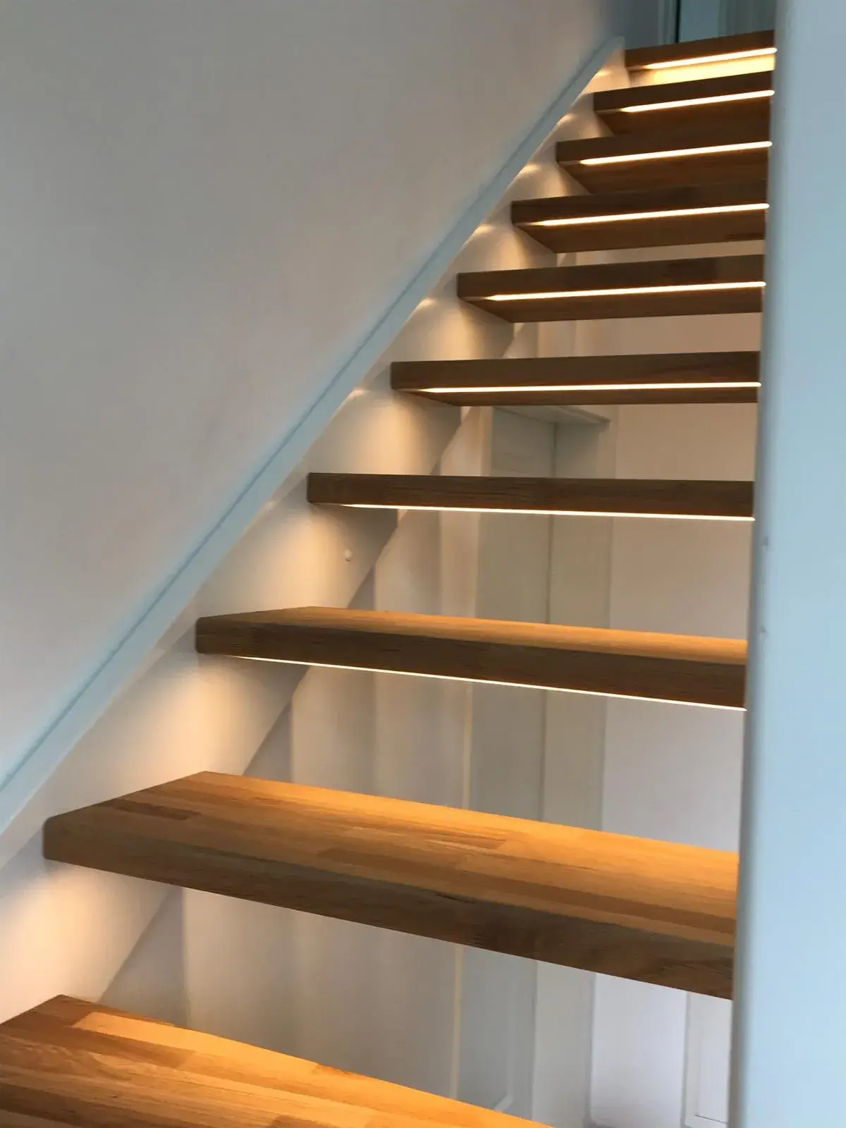 Maßgefertigte Holztreppe mit offenen Stufen und integrierter LED-Beleuchtung