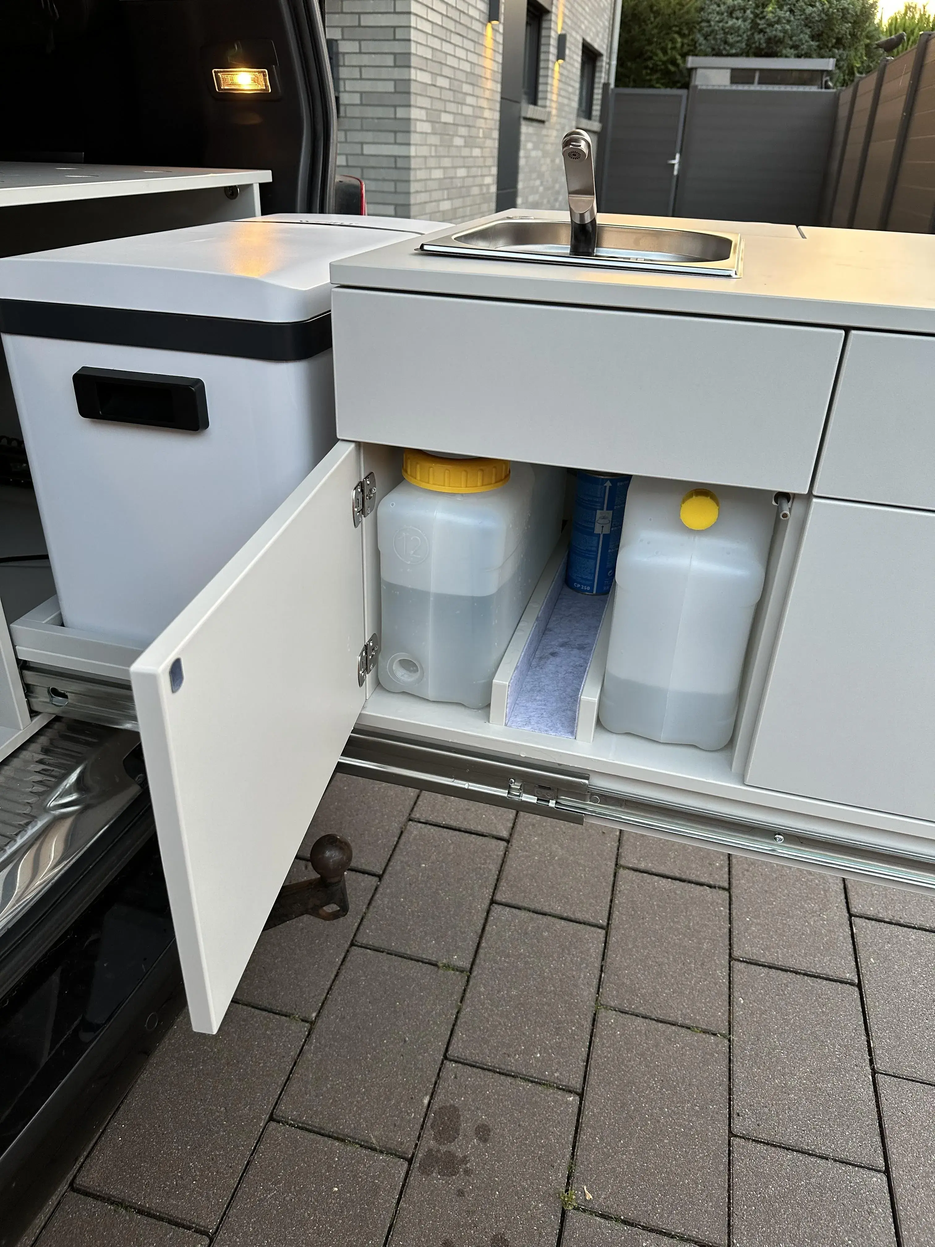 Ausziehbare Campingküche mit Spüle, Kühlbox und integriertem Frisch- und Abwassertank im Fahrzeugheck