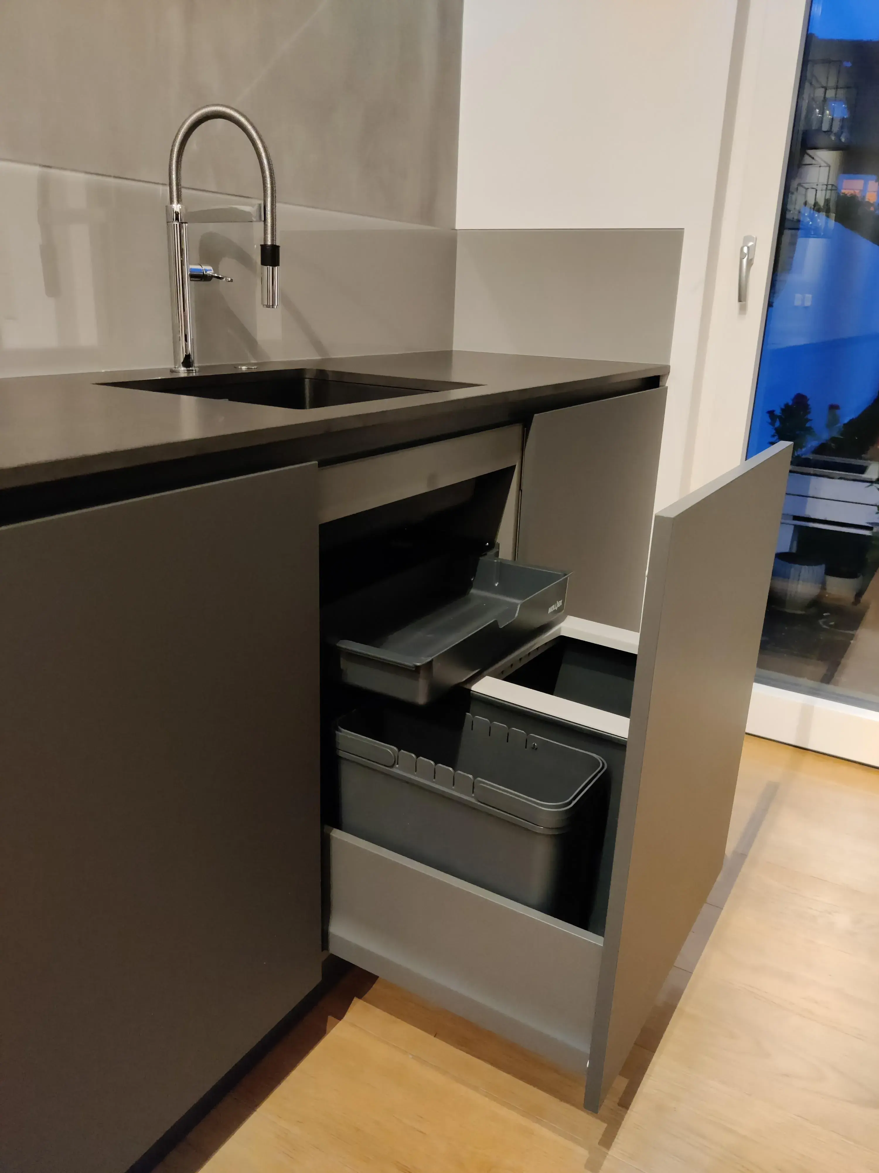 Moderner Spülenunterschrank mit ausziehbarem Abfalltrennsystem und schwarzer Küchenspüle