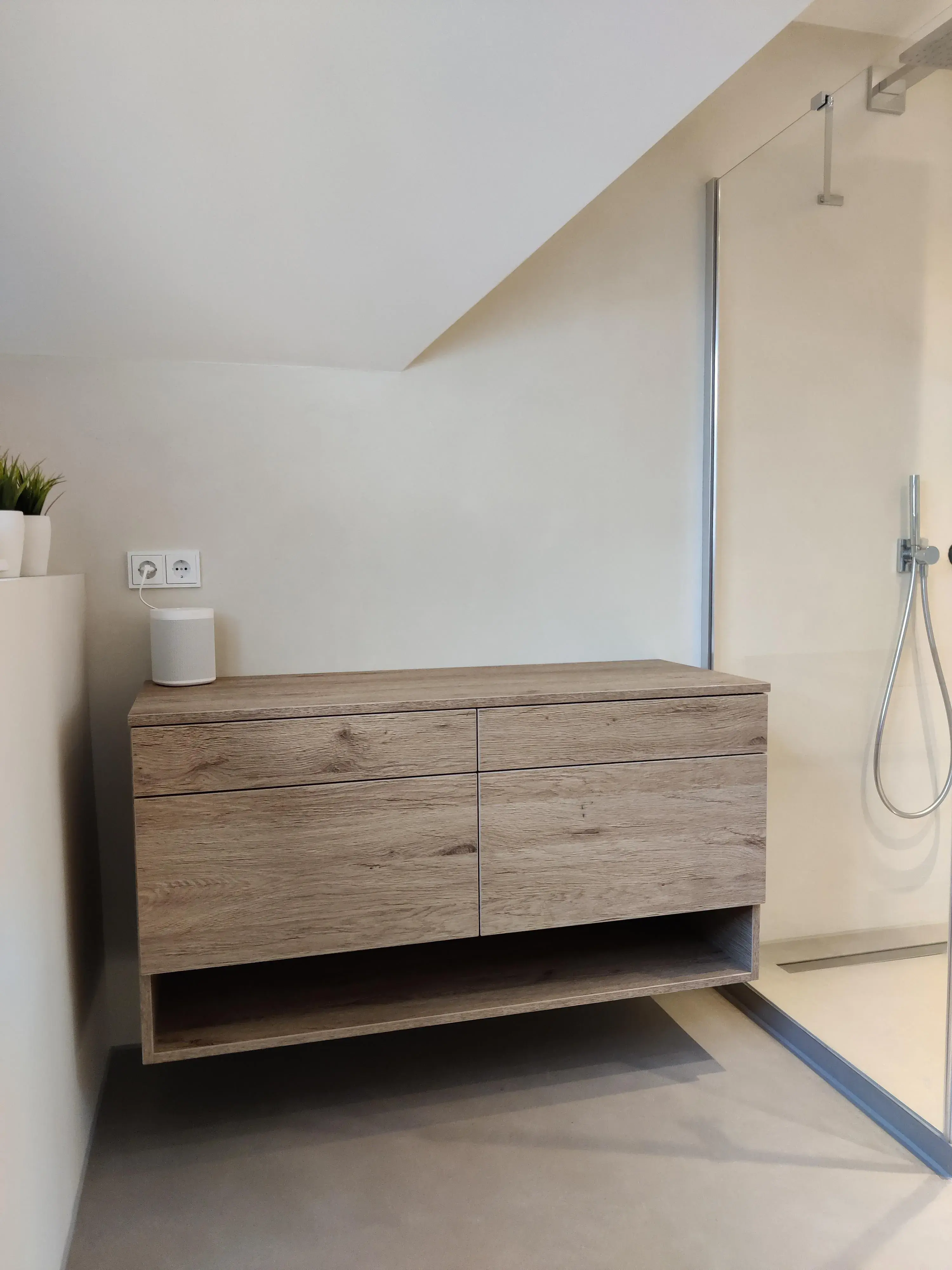 Moderner schwebender Waschtischunterschrank in Holzoptik mit grifflosen Fronten neben bodengleicher Dusche