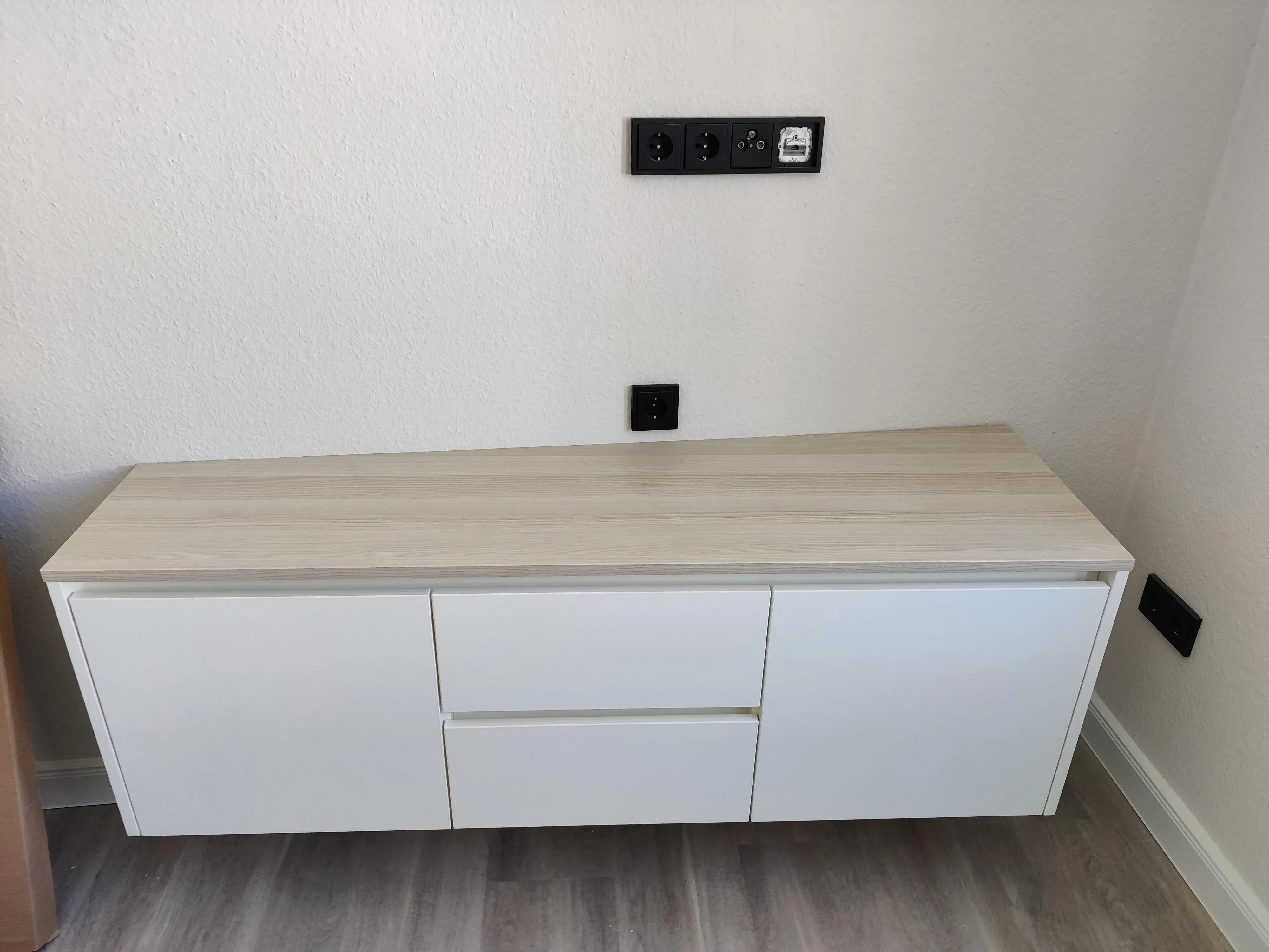 Maßgefertigtes weißes TV-Lowboard mit Schubladen und heller Holzoberfläche