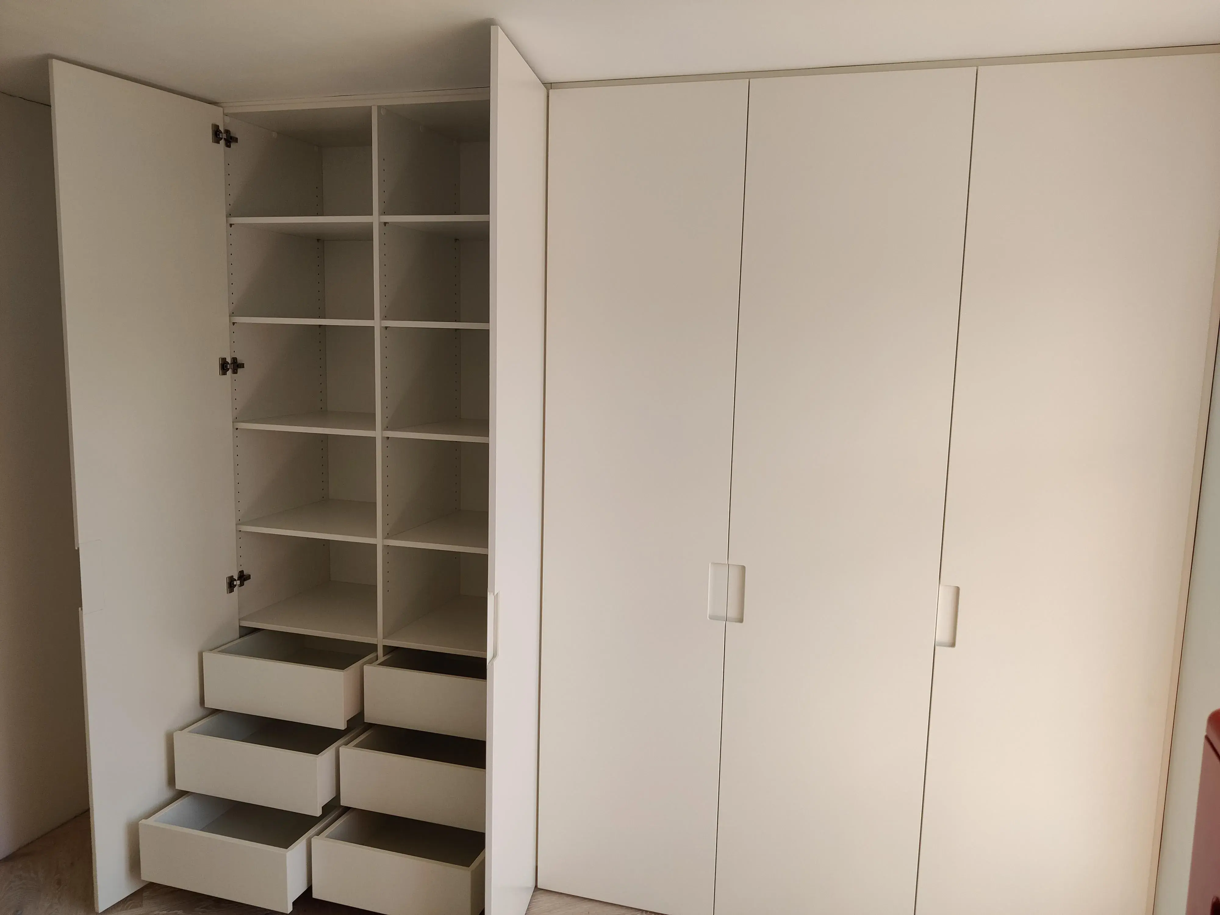 Geöffneter maßgefertigter Einbauschrank in Weiß mit Regalböden und Schubladen - weitere Ansicht