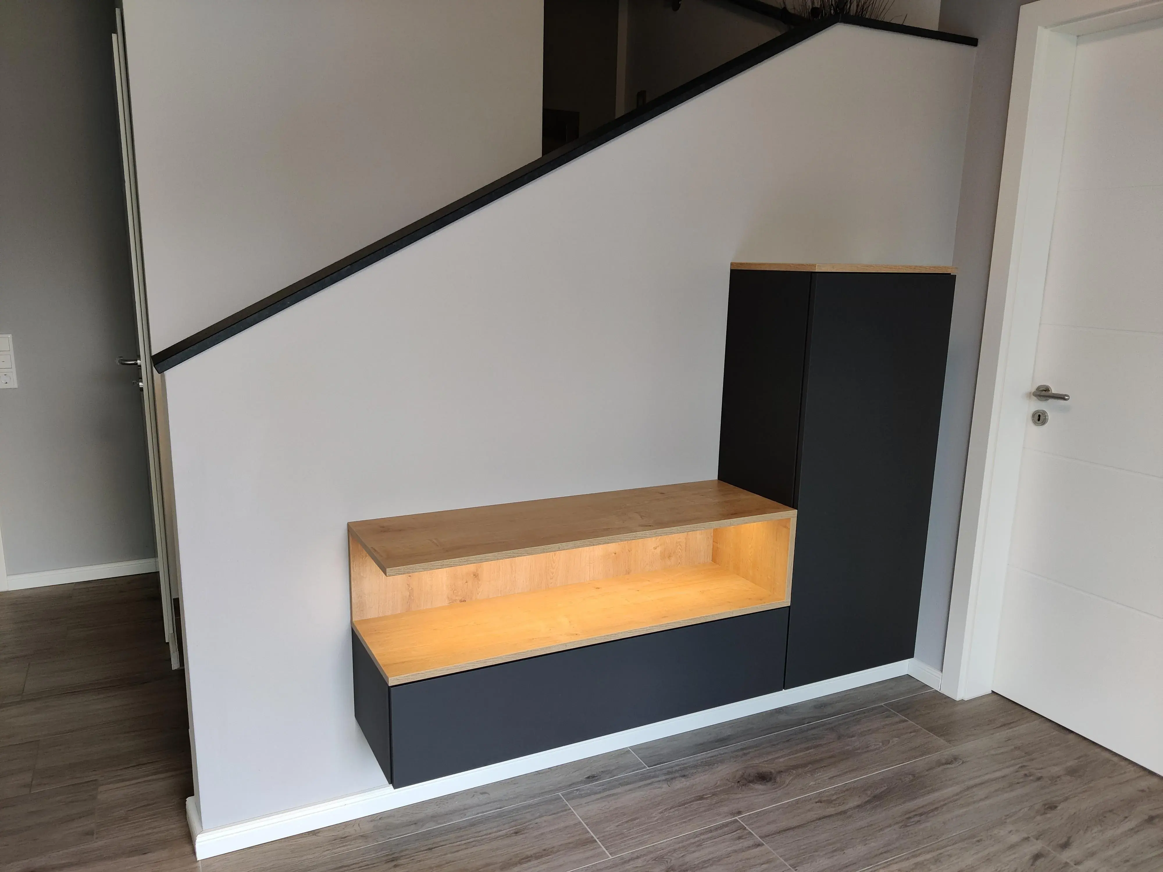 Maßgefertigte Flurgarderobe in Schwarz und Holzoptik mit beleuchteter Sitznische