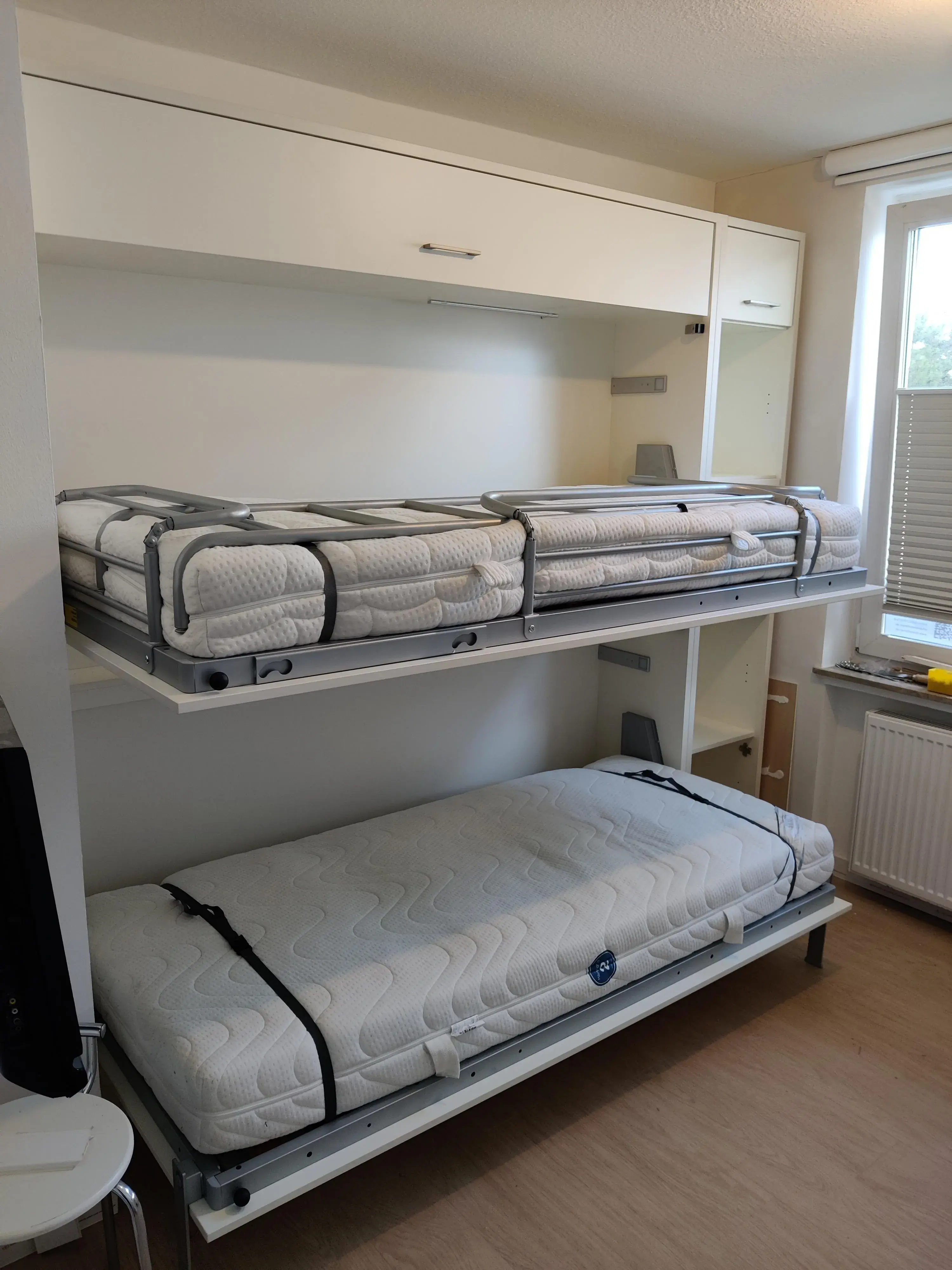 Platzsparendes Schrankbett mit zwei integrierten Schlafplätzen und maßgefertigtem Stauraum