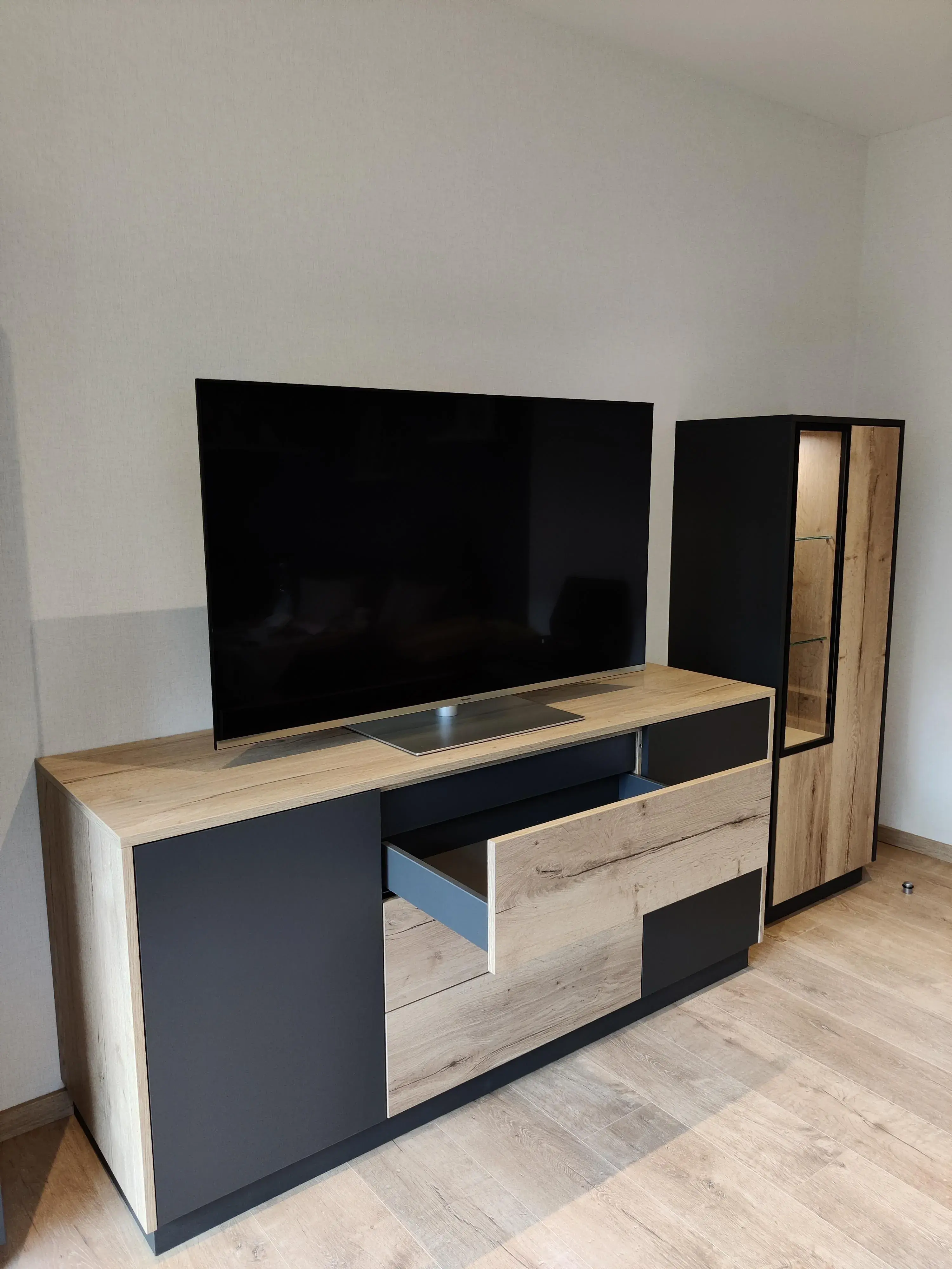 Maßgefertigtes TV-Möbel mit Schubladen und beleuchteter Vitrine in Holz und Anthrazit