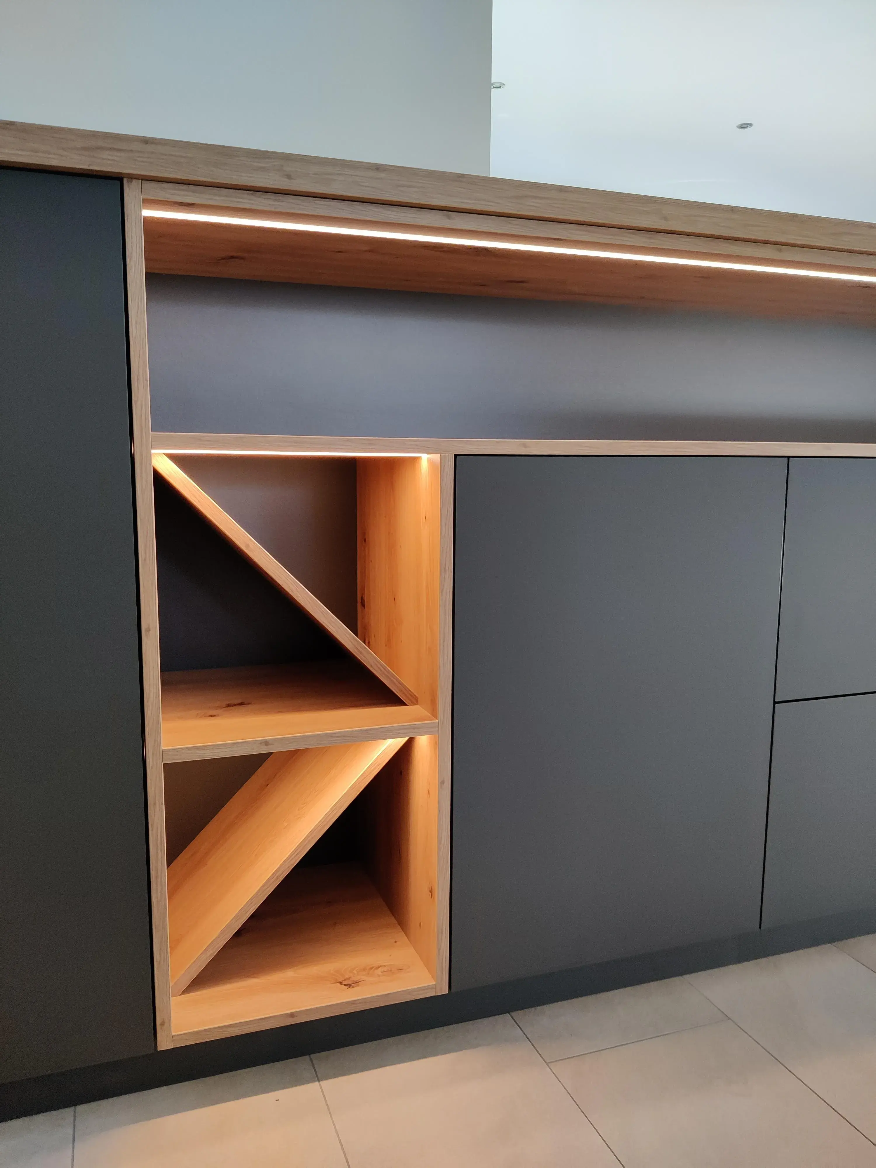 Moderner Einbauschrank in Anthrazit mit integriertem Holzregal und indirekter LED-Beleuchtung