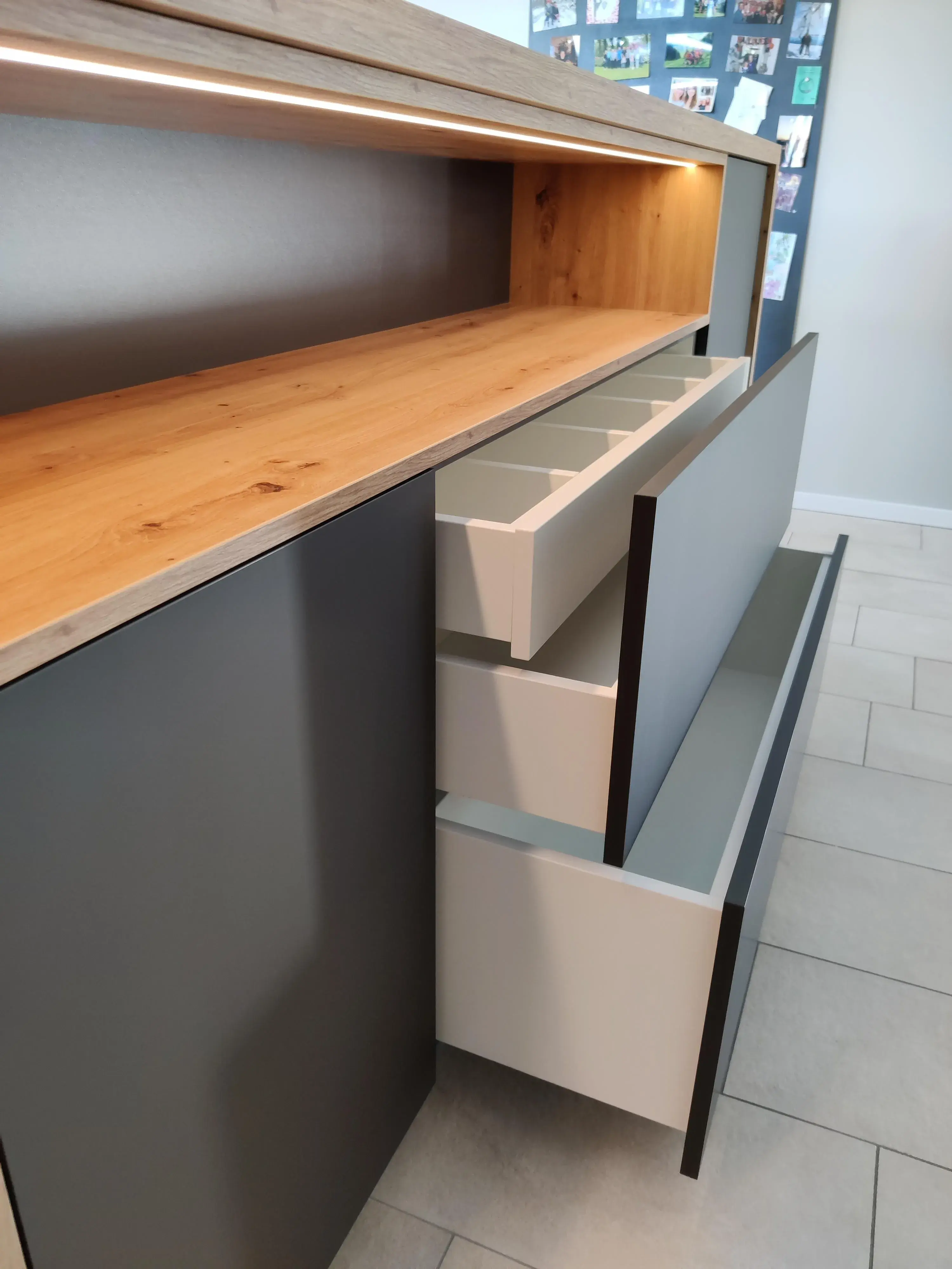Maßgefertigtes Sideboard in Anthrazit und Holz mit geöffneten Schubladen, Inneneinteilung und integrierter LED-Beleuchtung