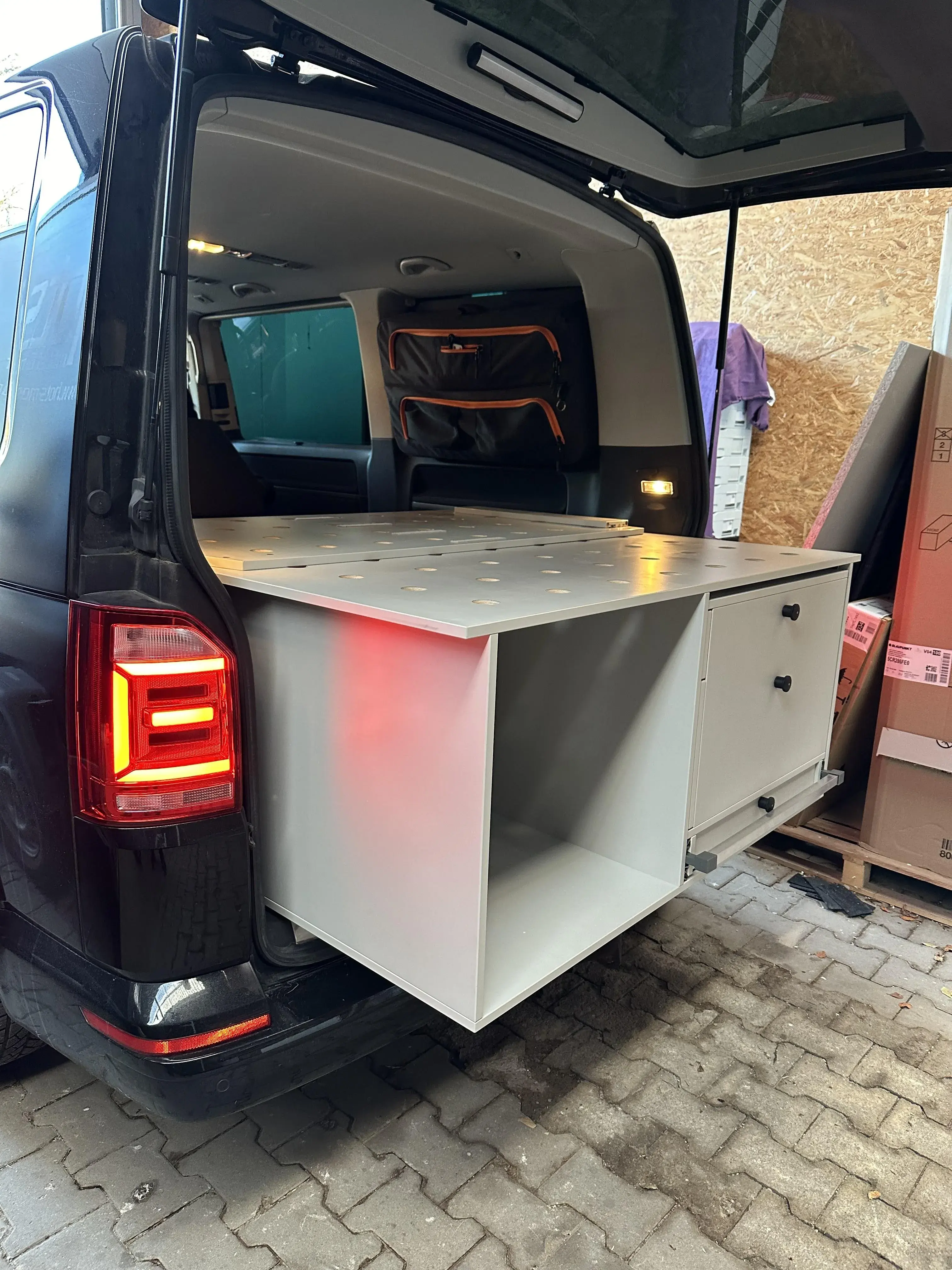 Campingfahrzeug mit ausziehbarem Heckausbau, großer Liegefläche, Schubladen und praktischem Stauraum
